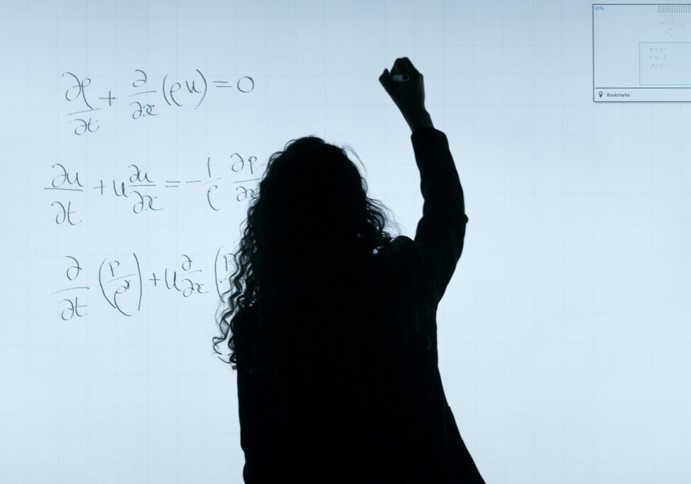 a woman writing on the white board
